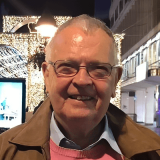 Portrait photo of Eilian Wyn wearing his glasses and brown coat